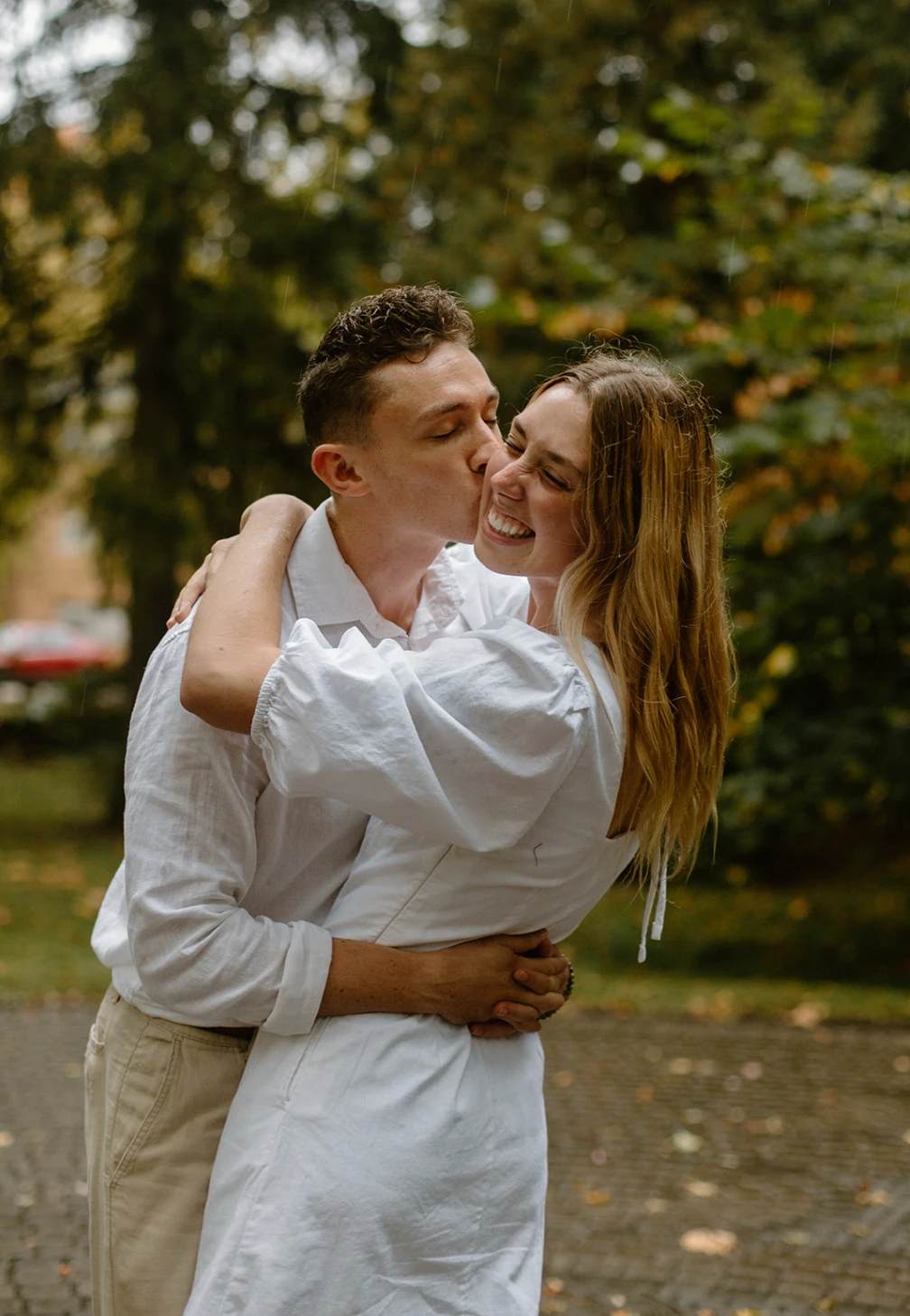 Gerrin kissing Meredith's cheek as she laughs under fall leaves